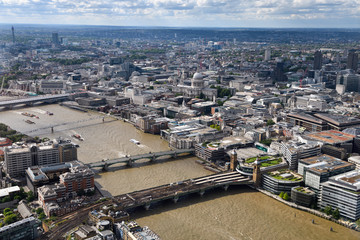 Fototapeta premium Aerial view of London England with BT Tower and bridges over the muddy River Thames and St Paul's Cathedral Anglican church