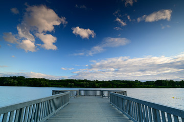 empty wooden pier and beautiful lake with forest on horizon 