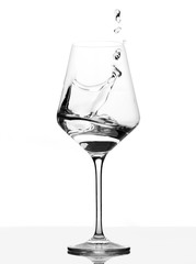 Clear Wineglass with burst of water. Motion against white