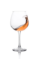 Glass of amber wine with splashes isolated on white.
