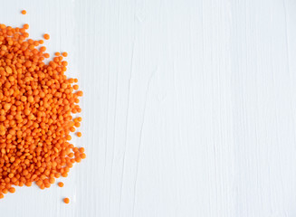 Lentils not boiled on a white wooden background with a place for copispeys. Porridge with a high content of protein. Lentil closeup
