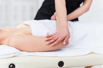 Young female masseur making massage in spa salon.