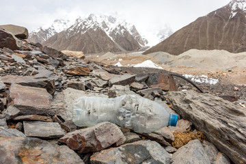 Garbage scattered over snowy mountain. Let's save the planet and recycle the excess garbage. Pollution Concept