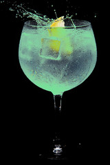 glass of gin tonic green and lemon