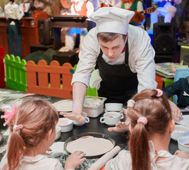 chef shows pizza base, on master class for kids