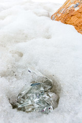 Garbage scattered over snowy mountain. Let's save the planet and recycle the excess garbage. Pollution Concept