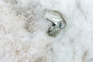 Garbage scattered over snowy mountain. Let's save the planet and recycle the excess garbage. Pollution Concept