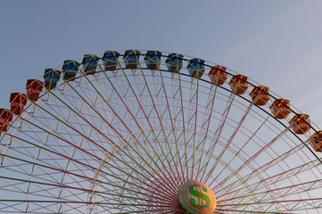 Colorful Ferris wheel in front of a blue sky. Big carousel in Gijon, Asturias, Spain.