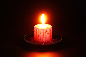 Fototapeta na wymiar Diy Halloween Halloween white candle covered in red wax like blood drops on black background.