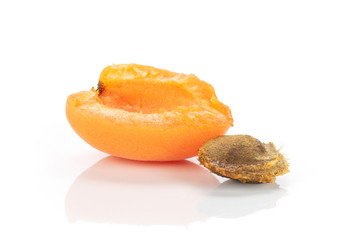 One half of ripe fresh deep orange apricot with a stone isolated on white background