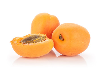 Group of two whole one half of velvety fresh deep orange apricot with a stone isolated on white background
