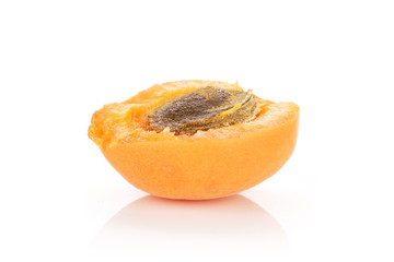 One half of fresh deep orange apricot with a stone isolated on white background