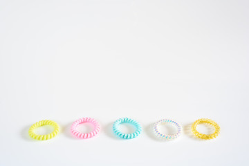 Plastic bracelets of various colors, isolated in a pattern arranged in white background.