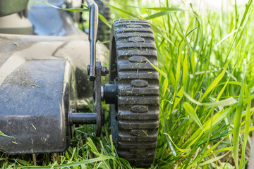 Wheels on electric lawn mower in garden to cut grass
