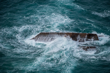 Stormy ocean waves crashing on rocks 