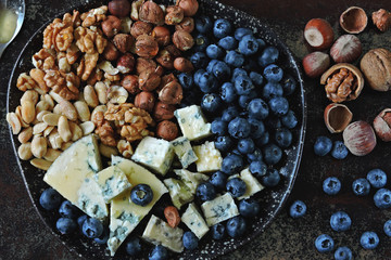 Cheese plate with blue cheese, nuts and blueberries. Healthy snack. Keto diet
