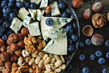 Obraz na płótnie Canvas Cheese plate with blue cheese, nuts and blueberries. Healthy snack. Keto diet