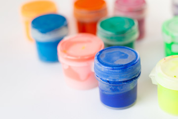 bright gouache paints on white background,multi-colored tubes of paints
