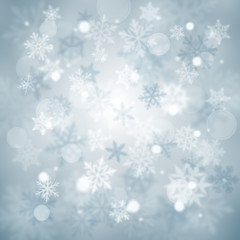 Christmas blurred background of complex defocused big and small falling snowflakes in light blue colors with bokeh effect
