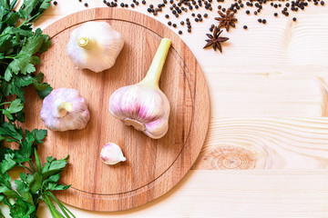 High point view on three pieces fresh garlic on wooden plate