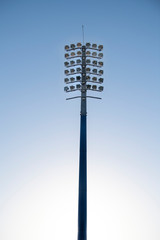 Sports stadium light tower during the day, set against a blue sky.