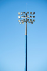 Sports stadium light tower during the day, set against a blue sky.