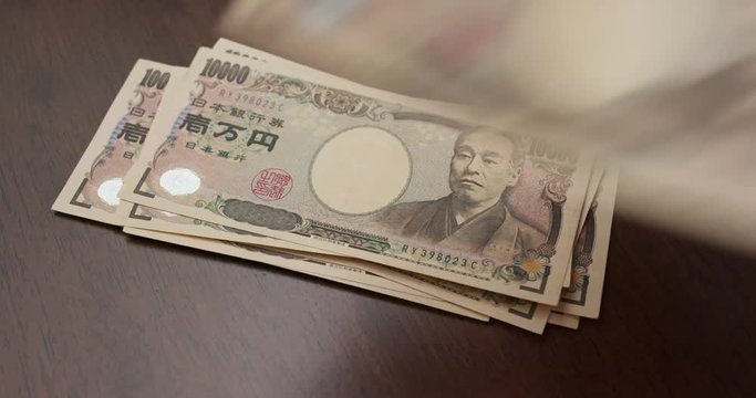 Counting Japanese Yen banknote on the table
