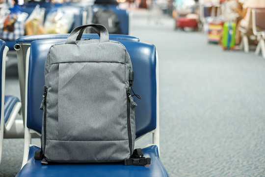 gray business backpack on seat at the interior of airport terminal. Business and Travel concept