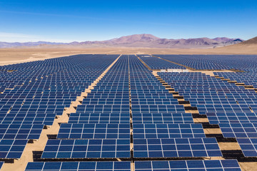 Aerial view of hundreds solar energy modules or panels rows along the dry lands at Atacama Desert,...