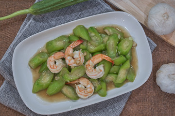 stir fried angled gourd with egg topping shrimp on dish