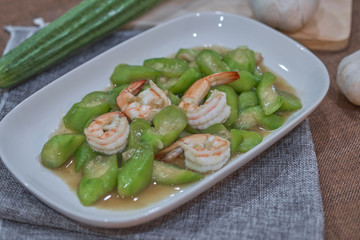 stir fried angled gourd with egg topping shrimp on dish