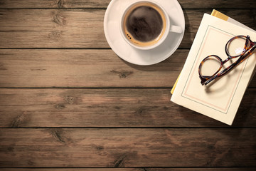 ビンテージなテーブルの上のコーヒー、本、読書のイメージ