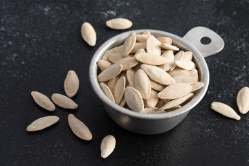 White Pumpkin Seeds Spilled from a Measuring Cup
