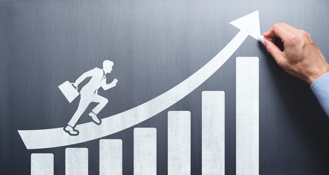 Business development and leadership concept. Business education. Drawing growth chart, arrow and running businessman on chalkboard.
