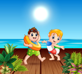 Obraz na płótnie Canvas Boys in shorts holding a lifebuoy at the pier