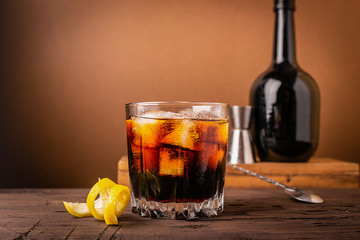 A glass of strong alcoholic drink whiskey brandy a glass glass with ice cubes dark wooden background. Selective focus.