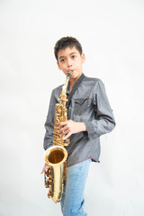 Fototapeta premium Little asian musician boy playing saxophone instrument