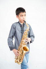 Fototapeta na wymiar Little asian musician boy playing saxophone instrument