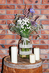 Bouquet of mixed wild flowers on rustic wooden barrell