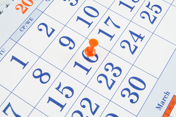 Red push pin in calendar page, event planning concept