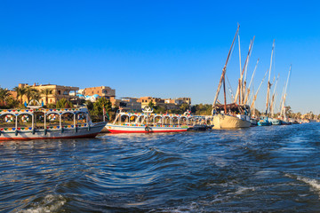 Fototapeta na wymiar Tourist boats moored near the shore of Nile river in Luxor, Egypt