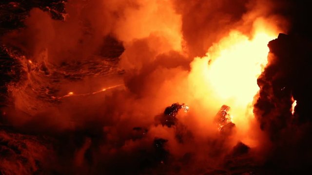 Lava flowing into the ocean from volcano lava eruption on Big Island Hawaii. Lava stream flowing in Pacific Ocean from Kilauea volcano around Hawaii volcanoes national park, USA. Night shot 59.94 FPS.