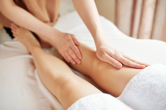 Close-up image of woman getting anti cellulite massage of legs in spa salon
