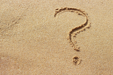 Question mark drawn on golden sand top view, copy space
