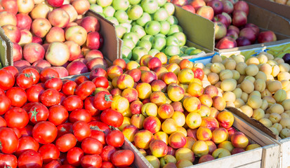 Tomato, peach, apricot, apples on the counter in the market