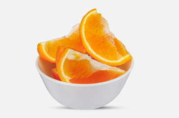 Sliced orange lies in the plate. On a white background close-up.