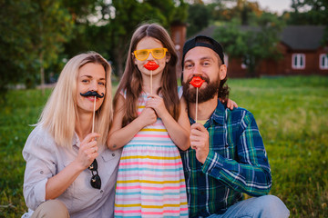 Funny man, woman and child with protruding tongues in rocker style scream.