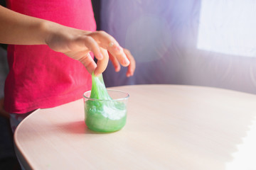 Children's hands take an opposite slime from a jar