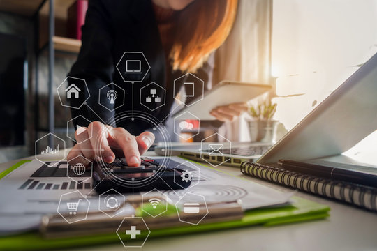 Business women calculates financials with graph paper on the smart phone on the cost of home office.