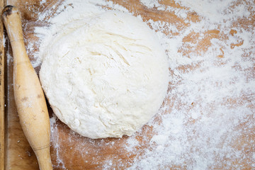 Rolling pin and dough on wooden Board. Dough for baking. Top view.